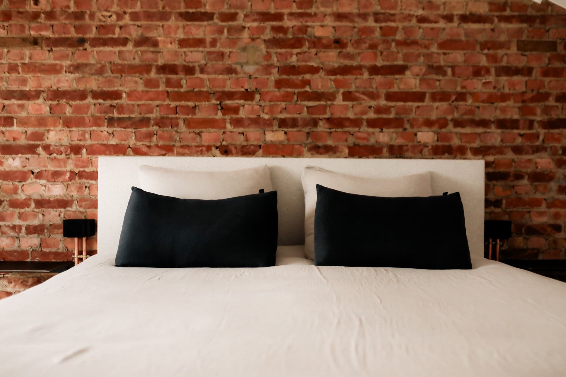 Chambre avec lit double et mur de briques apparentes